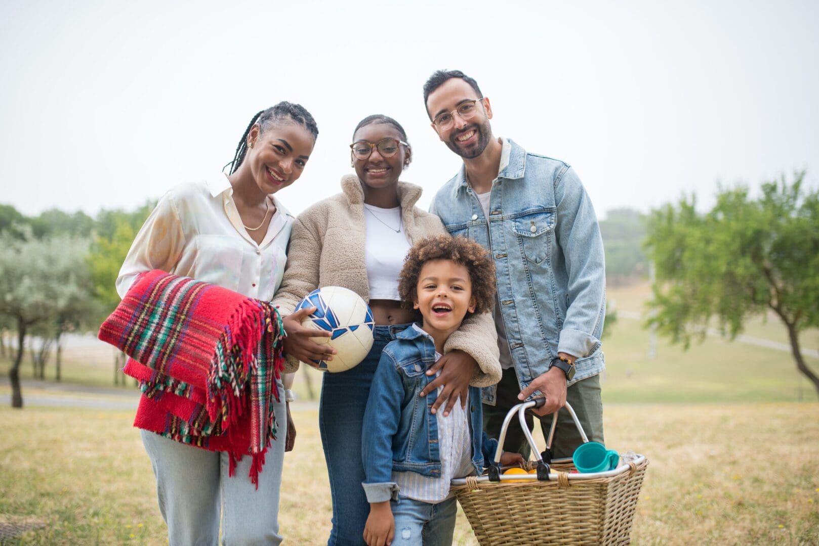 A group of people standing in the grass with baskets.